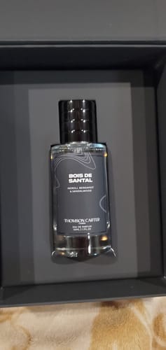 Customer's Bois De Santal Eau de Parfum bottle sitting upright inside its dark presentation box.