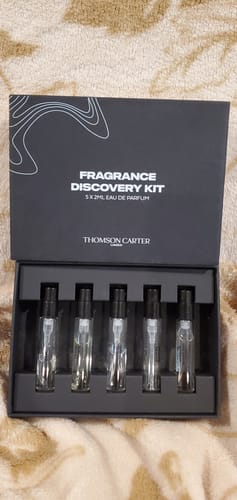 Customer's open black Fragrance Discovery Kit showing five 2ml Eau de Parfum sample vials inside.
