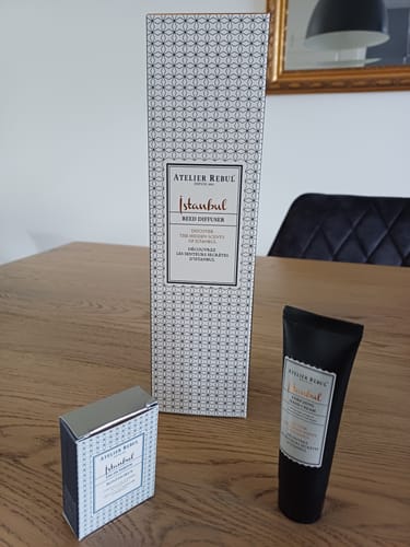 Beoordelaar's verpakking voor de Istanbul Geurstokjes, naast twee andere producten uit dezelfde lijn op een houten tafel.