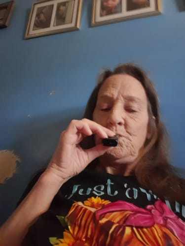 Customer using the black Relief Vape, appearing relaxed with their eyes closed.