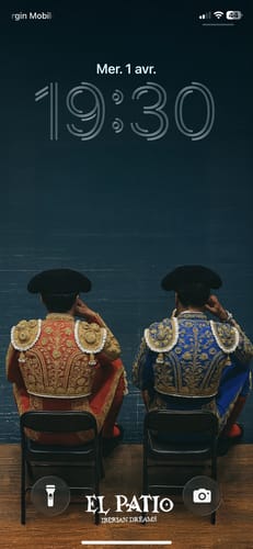 Customer's phone lock screen with the Courtside Bullfighters Wallpaper showing two bullfighters in ornate outfits from behind.