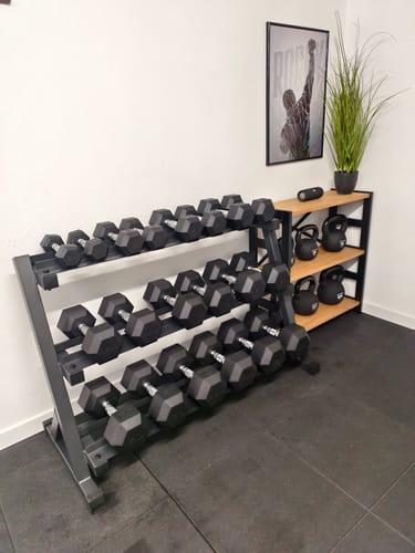 Kundenbild der schwarzen HellHound Hantelablage, voll bestückt mit Kurzhanteln in einem Trainingsraum.