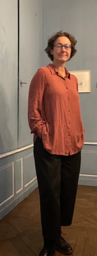 Cliente portant le Pantalon Briac noir à la coupe ample, les mains dans les poches.