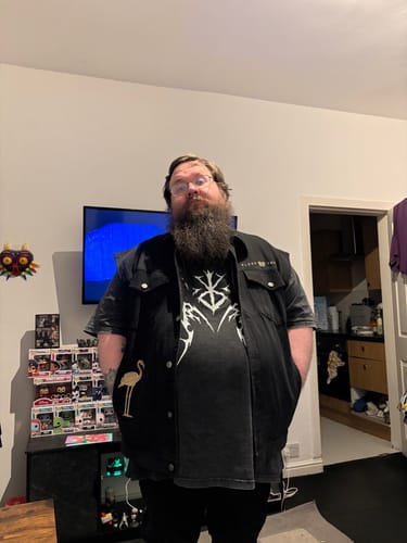 Reviewer wearing the black Sleep Token vest, showing the front and a small embroidered flamingo on the pocket.