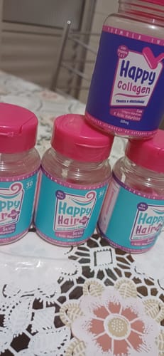 Cliente mostra três potes de Happy Hair e um pote de Happy Collagen sobre uma toalha de renda.