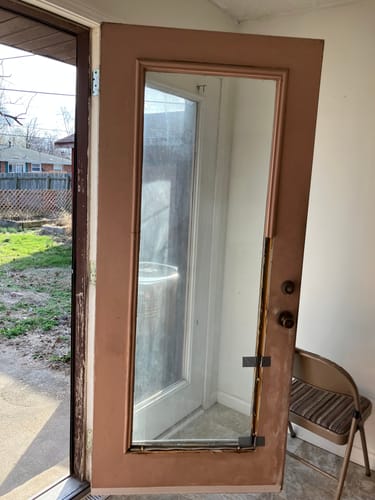 Reviewer's brown door with its damaged full lite frame removed from the door frame before installation.