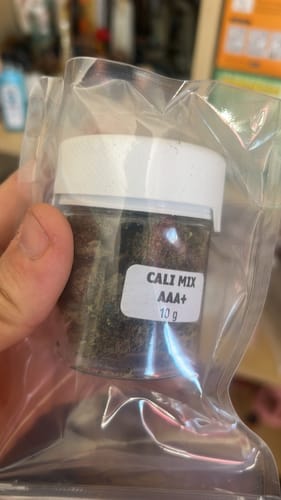 Customer holding a 10g jar of CALI MIX AAA+ in its clear plastic packaging.