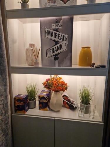 Customer's personalized street sign canvas displayed on a white lighted shelf.