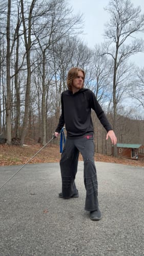 Reviewer in a fencing pose wearing the black Crusader Armor Joggers outdoors with a sword.