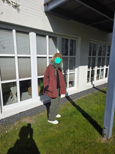 Reviewer wearing the oversized red Retro Cotton Coat outdoors with a green scarf.