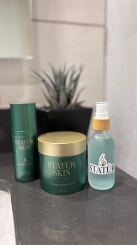 Reviewer's Restoration Ritual Set showing the three products arranged on a dark bathroom counter.