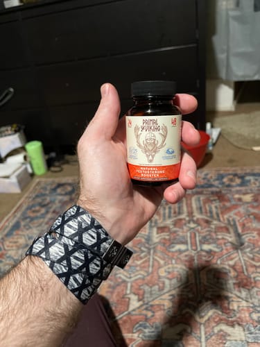 Customer holding a brown bottle of the Primal Reindeer Testosterone Support.