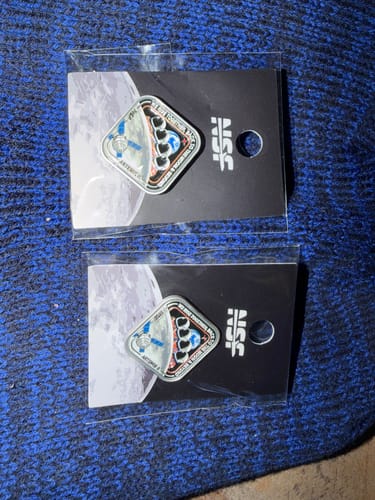 Customer's two Artemis II - Collectors Pins in their original packaging, displayed on their header cards against a blue background.