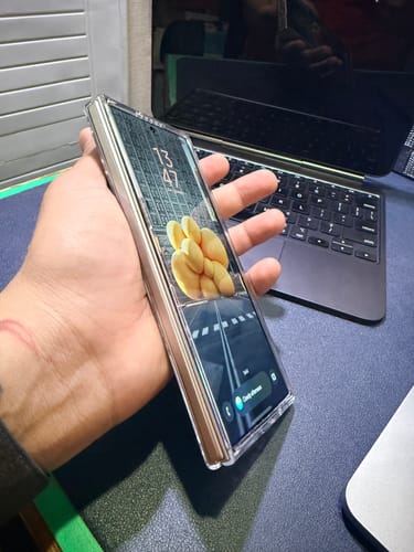 Customer holding a folded Galaxy Z Fold 7, showing the front screen through the clear anti-yellow case.