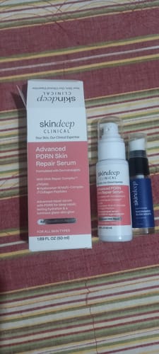 Reviewer's Advanced PDRN Skin Repair Serum bottle and box displayed next to another serum on a striped surface.