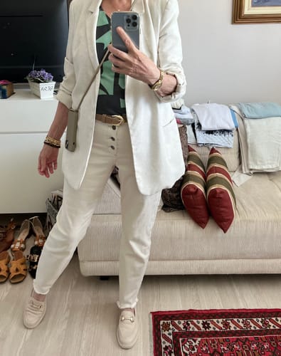 Avaliadora usando a Case Areia com alça atravessada no corpo sobre um blazer.