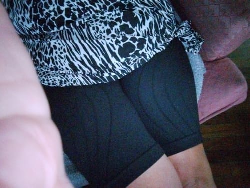 A customer sits wearing the black Silix™ Anti-Cellulite Legging shorts, showing a smooth fit on the thighs.