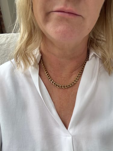 Customer wearing the gold 8mm Cuban Link Necklace with a white shirt.
