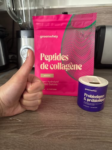 Client faisant un pouce levé à côté d'un sachet rose de Peptides de Collagène sur un comptoir.