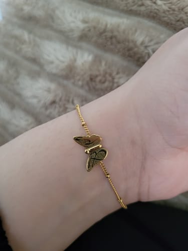 Customer wearing the gold Patience & Hope Bracelet, showing the engraved butterfly charm on their wrist.