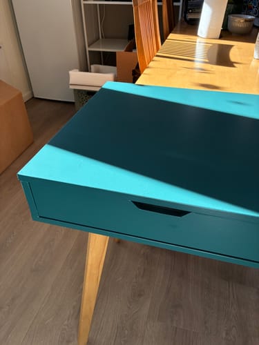 Kundens nærbilde av et møbel dekket med den matte, mørkegrønne kontaktplasten.