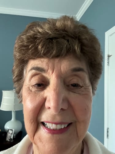 A close-up photo of the smiling reviewer's face.