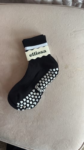 Customer's black Dual-Direction Grip Stripes sock with white stripes and non-slip grips on the sole.