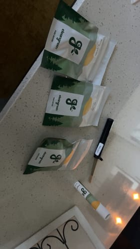 Customer's order of Roll Ready Ground flower, with three pouches and a pre-roll on a countertop.