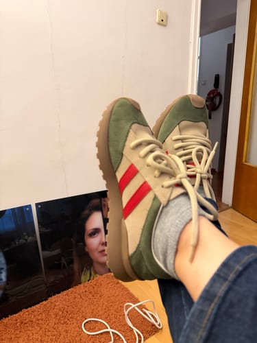 A reviewer wearing the green and tan Vintage Colorblock Sport Shoes with their feet up.