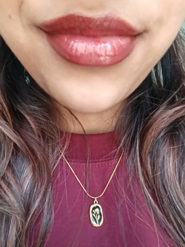 Close-up of a reviewer wearing the Peptide Lip Glaze in the shade deep berry.