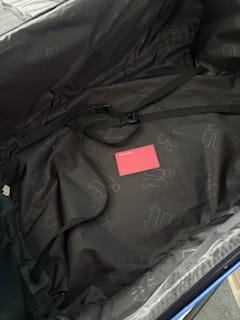 Reviewer's red SPOTMINDERS Tracking Card shown inside an open suitcase.
