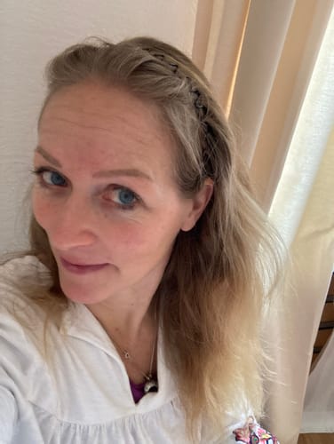 Kundin zeigt ihr blondes, glattes Haar nach der Anwendung der 15% Ylang-Ylang-Glow Haarseife.