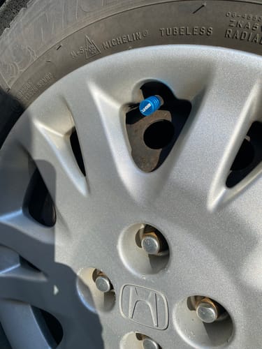 Customer's teal 80Eighty Valve Stem Cap installed on a silver Honda wheel, showing a close-up on the tire.