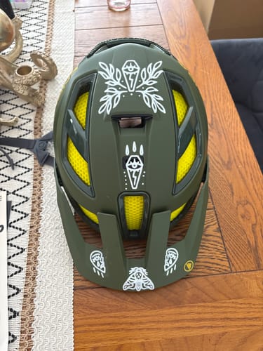 Customer's white Occult Transfer Decals applied to a dark green bike helmet.
