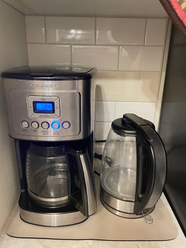 Customer's Magic Dish Mat on a coffee counter, with a coffee maker and kettle placed on top.