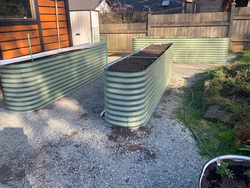 Reviewer's three 32-inch tall modular garden beds arranged on a gravel patio and filled with soil.