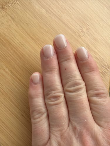 Hand einer Kundin mit glänzenden Babyboomer Nude Nagelfolien nach einer Woche Tragezeit.