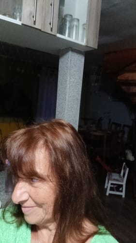 Clienta mostrando su cabello de tono cobrizo y brillante después de aplicar la Henna Jamila BAQ.