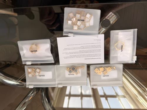 Reviewer's 5 jewelry pieces from the clearance sale, neatly arranged in their individual packages on a glass table.