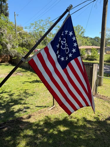 Customer's America 250™ Betsy Ross Flag mounted on a flagpole in a yard.