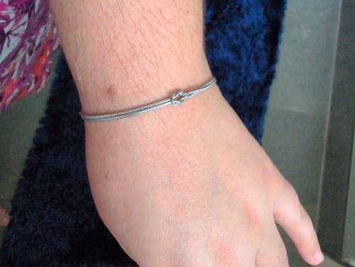 Customer wearing the delicate Forever Knot Bracelet on their wrist.