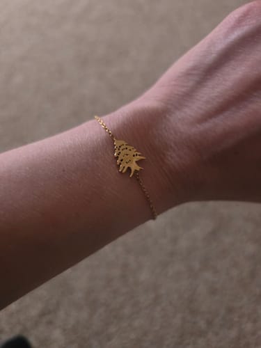 Customer wearing the delicate gold Cedar Tree Bracelet on their wrist.