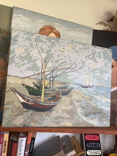 Reviewer's completed canvas from the Van Gogh 'Fishing Boats' paint by numbers kit on a shelf.