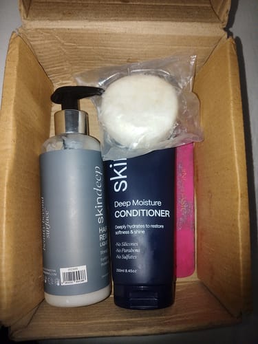 Customer's Hair Reviver Liquid Shampoo bottle inside a cardboard box next to a conditioner tube.