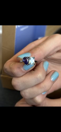 Customer holding the Toi Et Moi Birthstone Ring, showing its purple pear-cut and light blue emerald-cut stones.