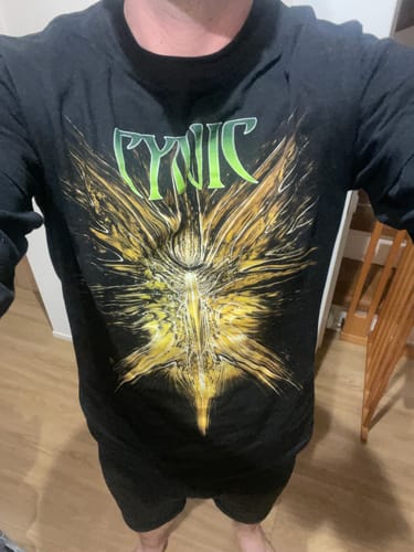 Reviewer wearing the black long-sleeve Cynic shirt, showing the fit and large front graphic.