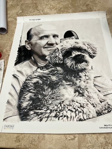 Customer's finished Custom Paint by Numbers Kit showing a black-and-white portrait of a man holding a fluffy dog.