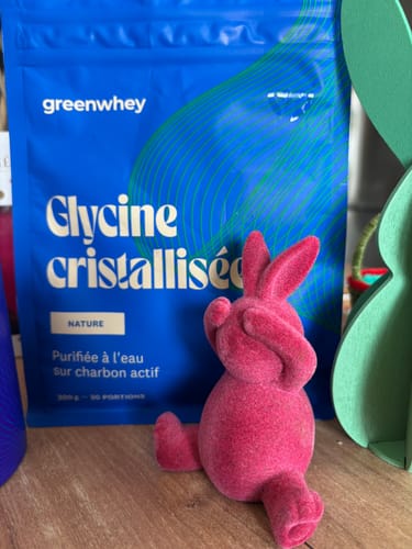 Cliente montrant son sachet bleu de Glycine cristallisée avec une figurine de lapin rose.