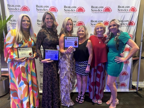 Reviewer in the animal print Naked Print Maxi Dress, posing with a group of people at an indoor event.