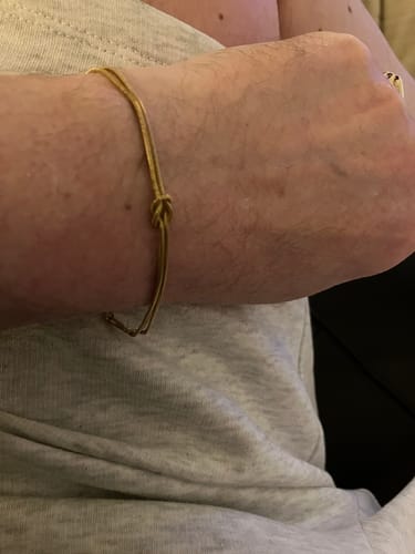 Customer showing a thin cord bracelet on their wrist, which arrived safely.